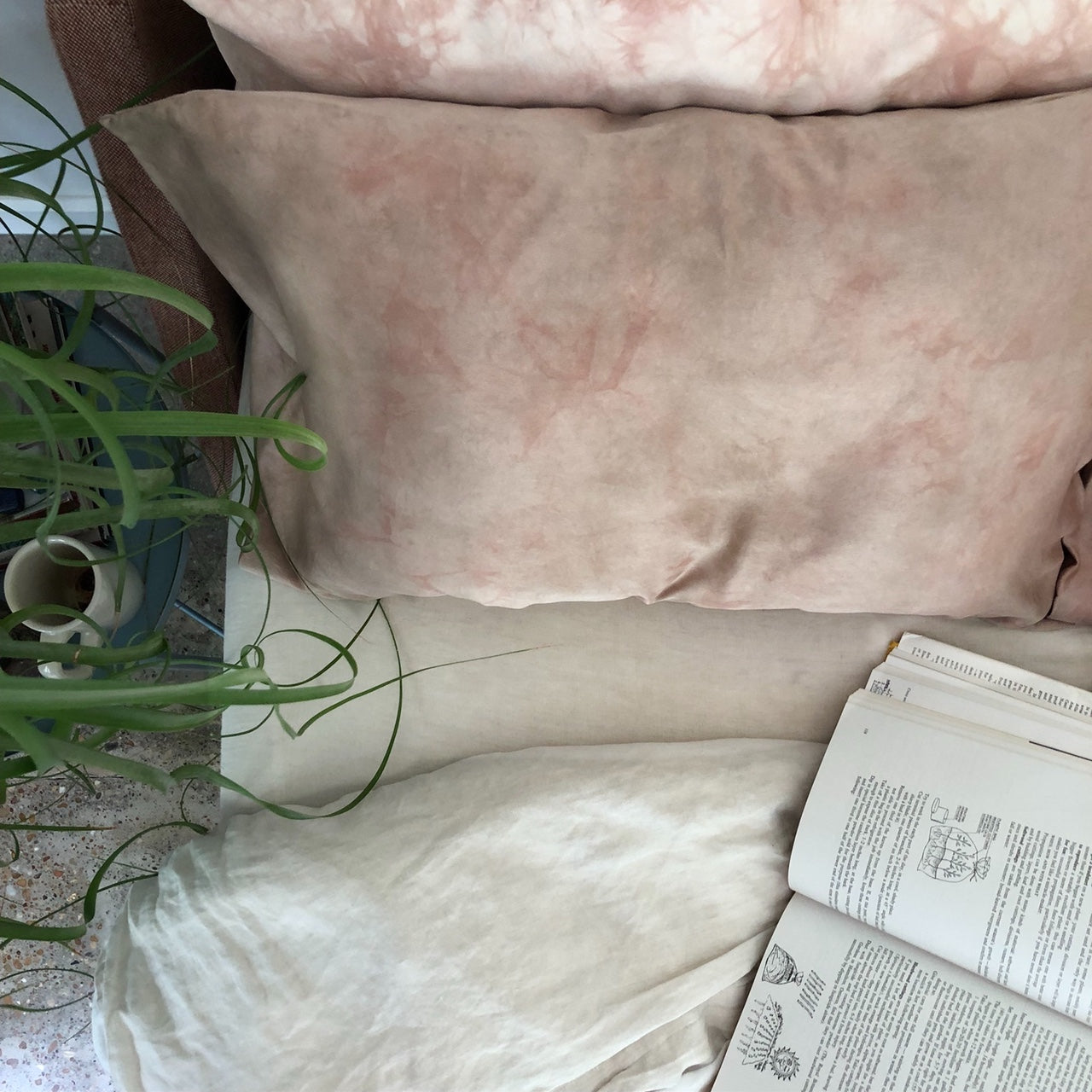 Silk Pillowcase Natural Dye Brown and Pink on a bed with plant