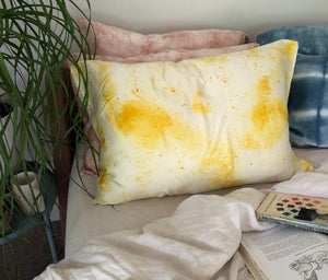 Yellow Naturally Dyed Silk Pillowcase on a bed with a plant