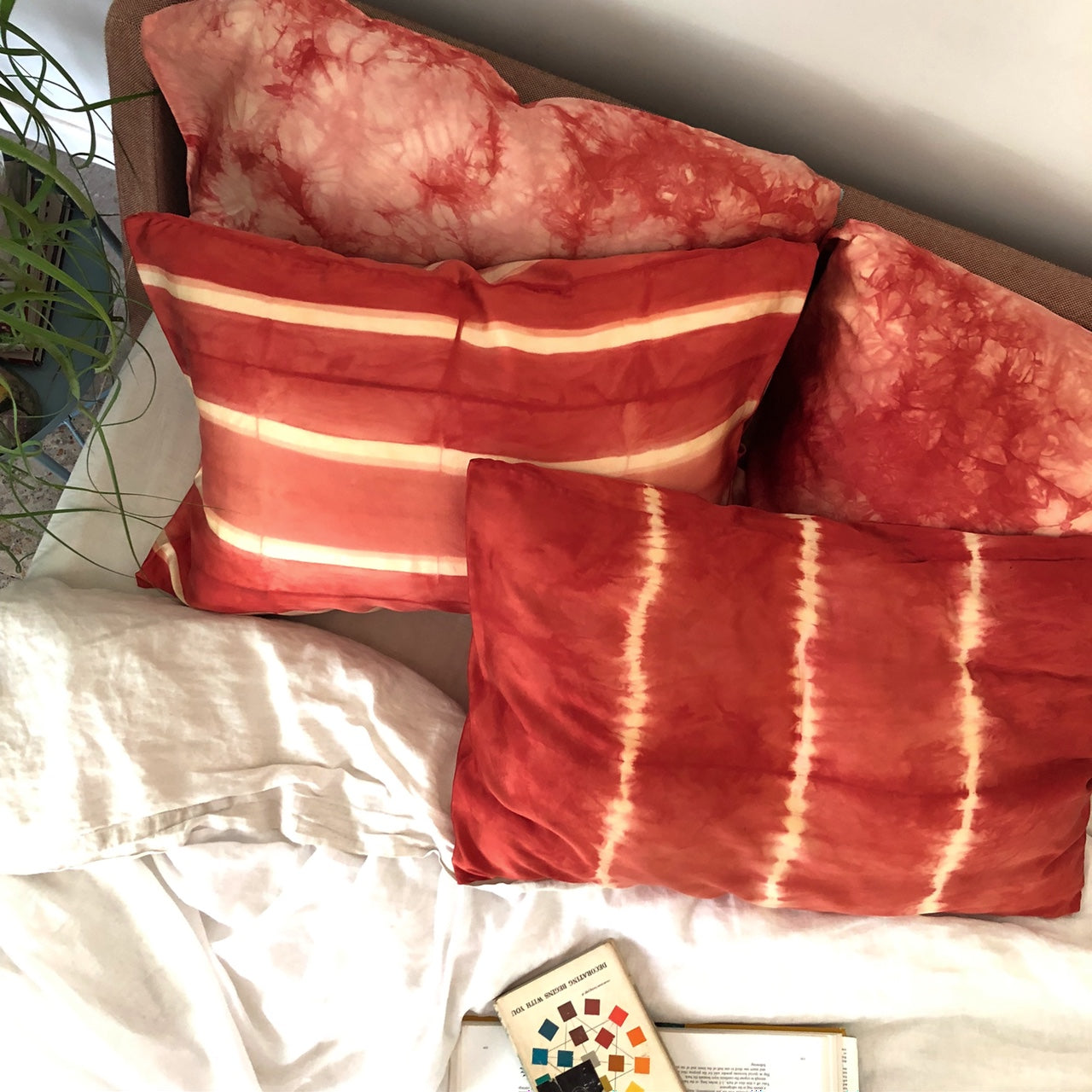 Madder red striped Silk Pillowcases from above on a bed with color theory books